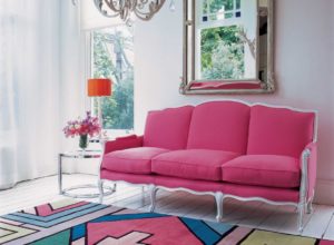 Пёстрый ковёр в комнате с розовым диваном